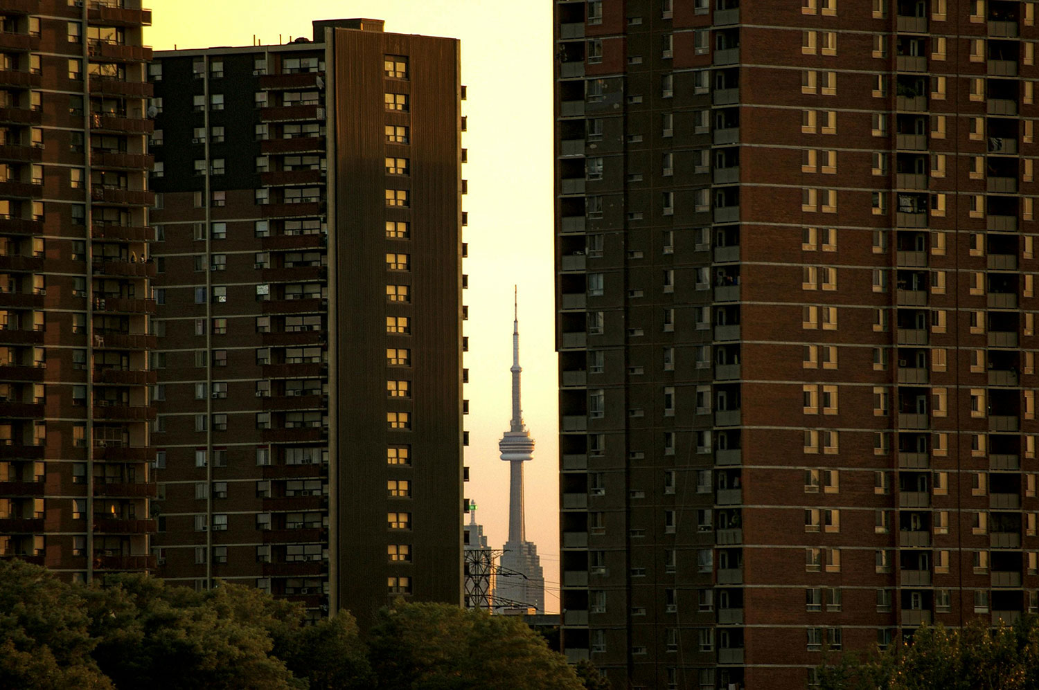 A long-shot photograph of two high-rise buildings with the CN Tower visible in the gap between them.
